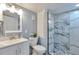 Modern bathroom featuring tiled shower, white vanity with sink, and contemporary finishes at 8262 Otis Ct, Arvada, CO 80003
