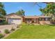 Charming brick home with a well-manicured lawn, cozy front porch with chairs, and a two car garage at 8262 Otis Ct, Arvada, CO 80003