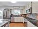 The kitchen features stainless steel appliances, granite countertops, and classic white cabinetry at 8262 Otis Ct, Arvada, CO 80003