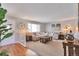 Bright living room with a large couch, wood floors, and a big window with natural light at 8262 Otis Ct, Arvada, CO 80003