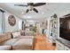 Open-concept living room with wood floors, ceiling fan, and a view into the bright kitchen at 8262 Otis Ct, Arvada, CO 80003