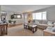 Inviting living room boasts a comfortable couch, wood floors, and large windows for ample natural light at 8262 Otis Ct, Arvada, CO 80003