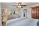 Well-lit main bedroom boasts light-colored furniture, a ceiling fan, and access to the ensuite bathroom at 8262 Otis Ct, Arvada, CO 80003