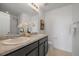 Bathroom with double sink vanity, large mirror, shower, and light colored flooring at 9608 Albion Ln, Thornton, CO 80229