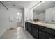 Bathroom featuring double sinks, dark cabinetry, and a shower at 9608 Albion Ln, Thornton, CO 80229