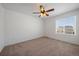 Spacious bedroom with carpet flooring, a ceiling fan, and a large window overlooking the neighborhood at 9608 Albion Ln, Thornton, CO 80229