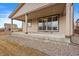 Covered back patio with brown trim, a concrete porch, and sliding glass doors into the home at 9608 Albion Ln, Thornton, CO 80229