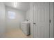 Convenient laundry room with a modern washer and dryer, tile floor, and natural light at 9608 Albion Ln, Thornton, CO 80229