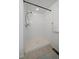 Walk-in shower with tile surround and white walls at 9608 Albion Ln, Thornton, CO 80229