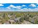 A high-angle view showcases a neighborhood filled with lush trees and various roof types under a bright, cloudy sky at 295 E Amherst Ave, Englewood, CO 80113