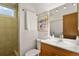Bathroom featuring a tiled shower, vanity with sink, and stylish mirror at 295 E Amherst Ave, Englewood, CO 80113