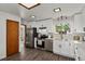Bright kitchen boasting white cabinets, subway tile, stainless steel appliances and wood-look floors at 295 E Amherst Ave, Englewood, CO 80113