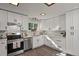 Well-lit kitchen featuring white cabinets, stainless steel appliances, and subway tile backsplash at 295 E Amherst Ave, Englewood, CO 80113