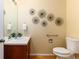 Half bath features a single sink vanity, toilet, and decorative wall art at 375 Aspenwood Ct, Lafayette, CO 80026