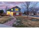Charming two-story home featuring a brick facade, green siding, and a welcoming stone pathway at 375 Aspenwood Ct, Lafayette, CO 80026
