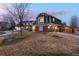 Well-maintained home featuring brick accents, green siding, an attached garage, and a spacious yard at 375 Aspenwood Ct, Lafayette, CO 80026