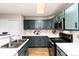 Bright kitchen with stainless steel appliances, dark green cabinets, and white countertops at 375 Aspenwood Ct, Lafayette, CO 80026