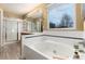 Bright main bathroom includes a soaking tub, walk-in shower, and natural light at 375 Aspenwood Ct, Lafayette, CO 80026