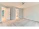 This bedroom features neutral carpeting, a ceiling fan, and an adjoining bathroom at 1121 W 112Th Ave # C, Denver, CO 80234