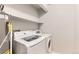 Convenient laundry area featuring a modern washer and dryer set with overhead shelving for storage at 1121 W 112Th Ave # C, Denver, CO 80234