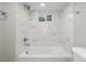Bright bathroom with a white marbled shower-tub combo and a window at 2260 S Lewiston St, Aurora, CO 80013