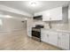 Well-lit kitchenette features stainless steel appliances and white cabinets, with light wood-look flooring at 2260 S Lewiston St, Aurora, CO 80013