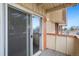 Balcony featuring a sliding glass door, wood decking, and a view of the community parking area at 10211 Ura Ln # 2-207, Thornton, CO 80260