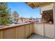 Balcony with a view of the community buildings, mature trees, and assigned parking for residents at 10211 Ura Ln # 2-207, Thornton, CO 80260