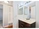 Bathroom featuring a single sink vanity with dark wood cabinets, mirror, and laminate wood flooring at 10211 Ura Ln # 2-207, Thornton, CO 80260