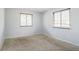 Carpeted bedroom with bright, neutral paint, and two windows providing ample natural light at 10211 Ura Ln # 2-207, Thornton, CO 80260