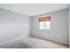 Carpeted bedroom featuring a neutral color scheme, bright natural light, and minimalist decor at 10211 Ura Ln # 2-207, Thornton, CO 80260