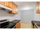 Cozy kitchen featuring wooden cabinets, modern appliances, and an adjacent dining area at 10211 Ura Ln # 2-207, Thornton, CO 80260