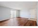 Open-concept living room features wood-look floors, a sliding door to a balcony, and a neutral color palette at 10211 Ura Ln # 2-207, Thornton, CO 80260