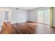 Bright living room with hardwood flooring, neutral walls, and a sliding door to a balcony at 10211 Ura Ln # 2-207, Thornton, CO 80260