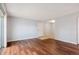 Wood-look floor in living room with sliding glass doors to a balcony, neutral walls, and closet space at 10211 Ura Ln # 2-207, Thornton, CO 80260