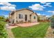 Landscaped backyard with a stamped concrete patio, green lawn, and well-manicured garden at 25811 E Archer Ave, Aurora, CO 80018