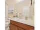 Bright bathroom featuring a vanity with wooden cabinets, a sink, framed mirror and a shower-tub combo at 25811 E Archer Ave, Aurora, CO 80018