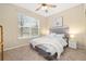 Cozy bedroom with a large window, ceiling fan, carpet flooring, and a comfortable queen-sized bed at 25811 E Archer Ave, Aurora, CO 80018