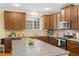 Kitchen featuring granite countertops, stainless steel appliances, wooden cabinets, and a center island with bar seating at 25811 E Archer Ave, Aurora, CO 80018