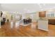 Open-concept living space with wood floors, a fireplace, and combined living, kitchen, and dining areas at 25811 E Archer Ave, Aurora, CO 80018