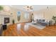 Cozy living room with fireplace, wood floors, a ceiling fan, and a door leading to the backyard at 25811 E Archer Ave, Aurora, CO 80018