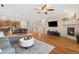 A spacious living room featuring a fireplace, tv, and open access to the kitchen and dining area at 25811 E Archer Ave, Aurora, CO 80018