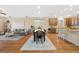 Open-concept living room features hardwood floors, neutral paint, and flows into the dining area and kitchen at 25811 E Archer Ave, Aurora, CO 80018