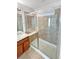 Bathroom features a glass shower with a built-in bench, wood cabinet, and neutral tile floor at 25952 E 5Th Pl, Aurora, CO 80018