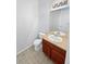 Half bathroom with a wood vanity cabinet, tile flooring, and a large mirror at 25952 E 5Th Pl, Aurora, CO 80018