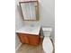 Bathroom featuring a wood vanity, white counter and toilet, and a decorative mirror at 25952 E 5Th Pl, Aurora, CO 80018