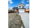 Two-story home featuring a brick facade, attached two-car garage, covered front porch, and a well-manicured lawn at 25952 E 5Th Pl, Aurora, CO 80018