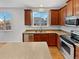 Bright kitchen features stainless steel appliances, wood cabinets, and views from the windows at 25952 E 5Th Pl, Aurora, CO 80018