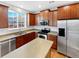 Well-lit kitchen featuring wooden cabinets, stainless steel appliances, and a functional island for cooking and entertaining at 25952 E 5Th Pl, Aurora, CO 80018