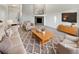 Living room with neutral tones featuring modern decor, a fireplace, plush seating, and a stylish area rug at 25952 E 5Th Pl, Aurora, CO 80018